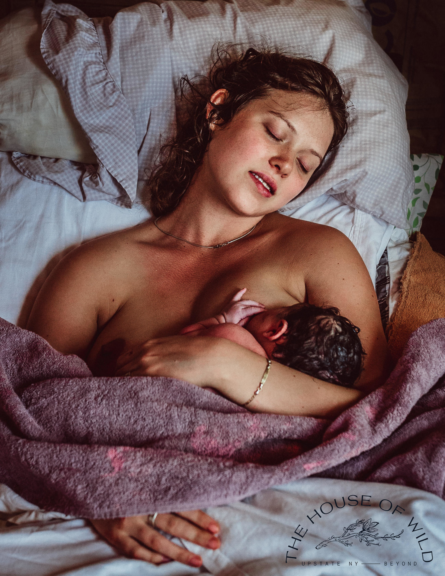Une mère allongée dans un lit allaite son nouveau-né