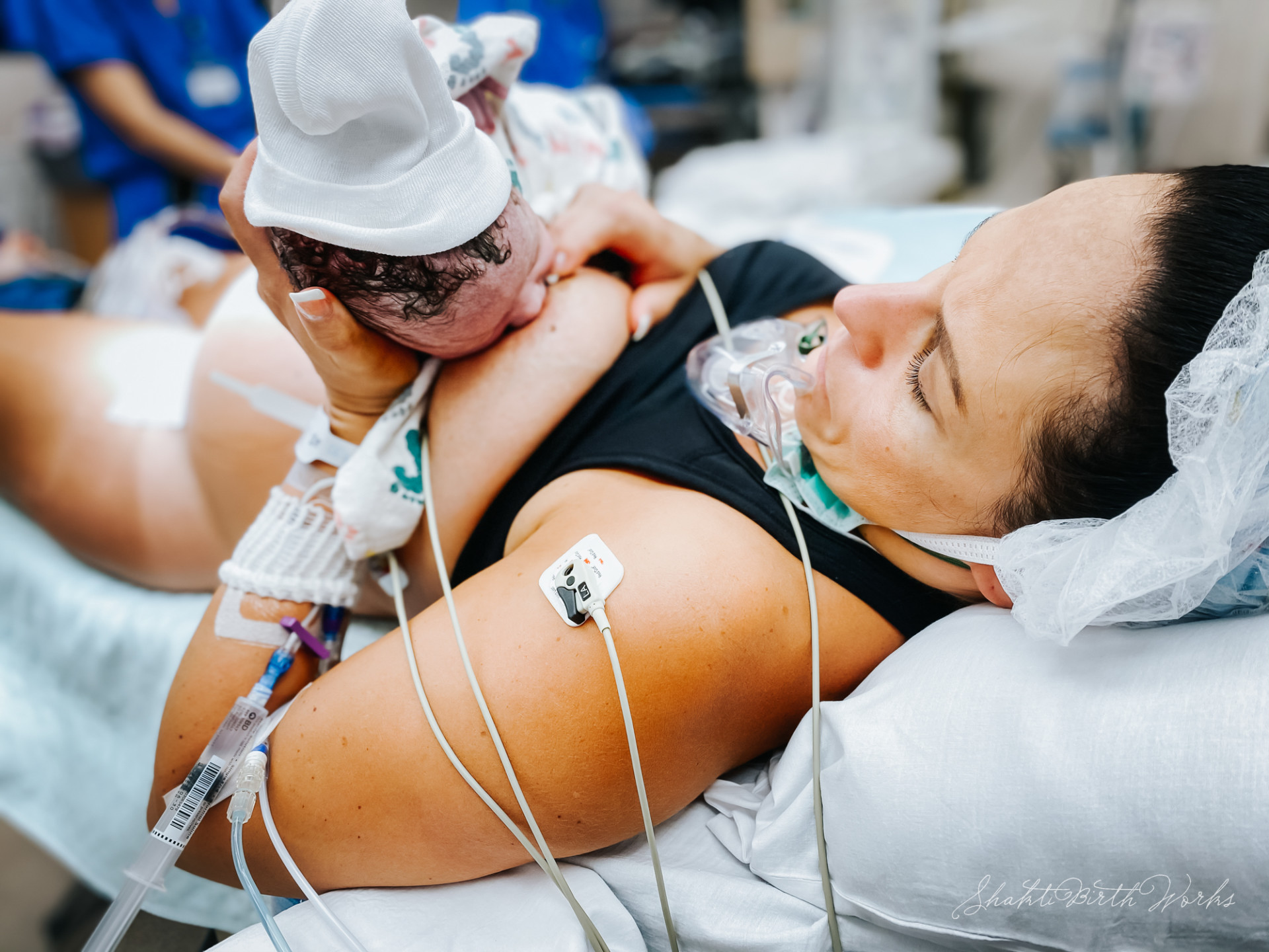 Une mère allongée dans un lit de maternité allaite son nouveau-né